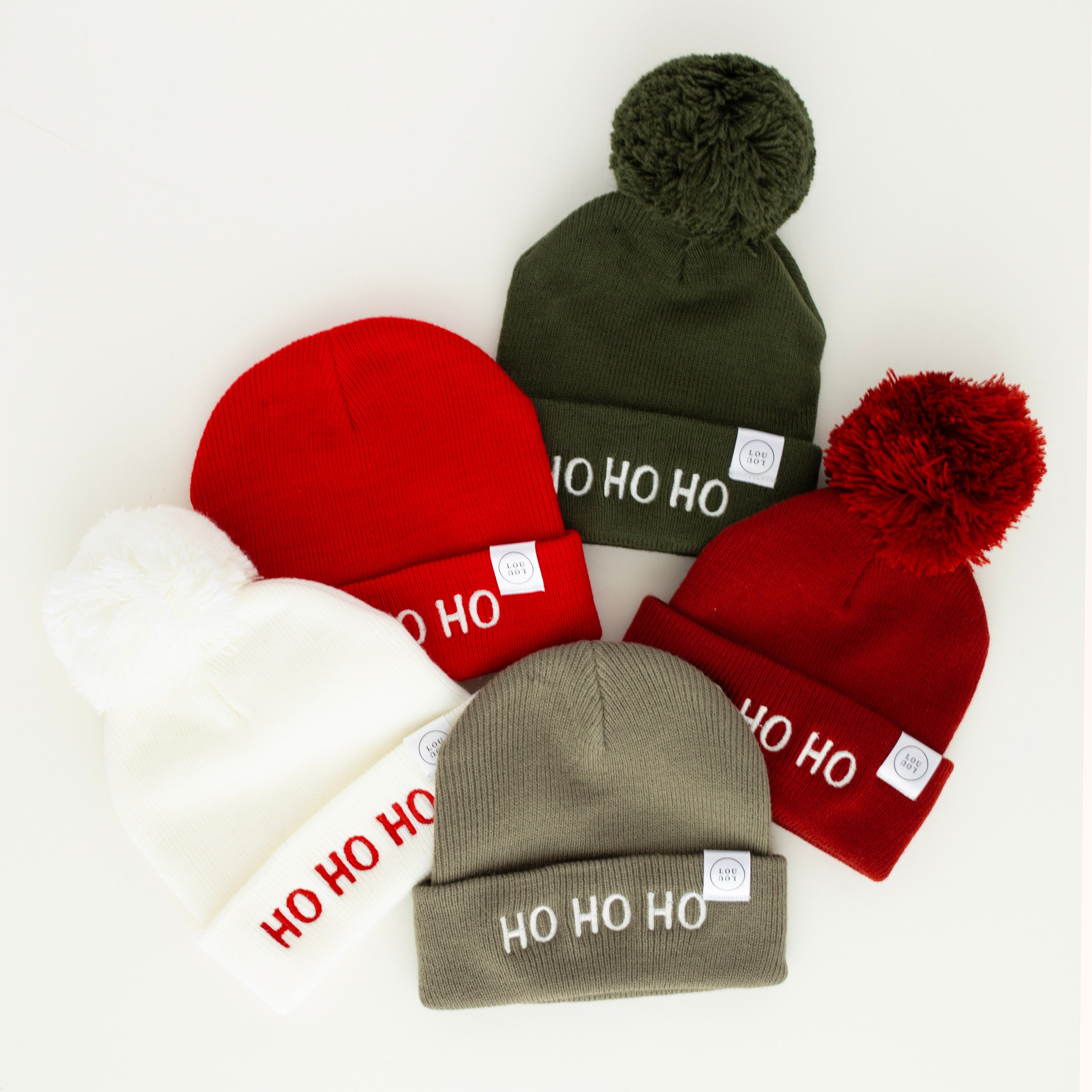 Four beanies with pom-poms and 'HO HO HO' text on a white background