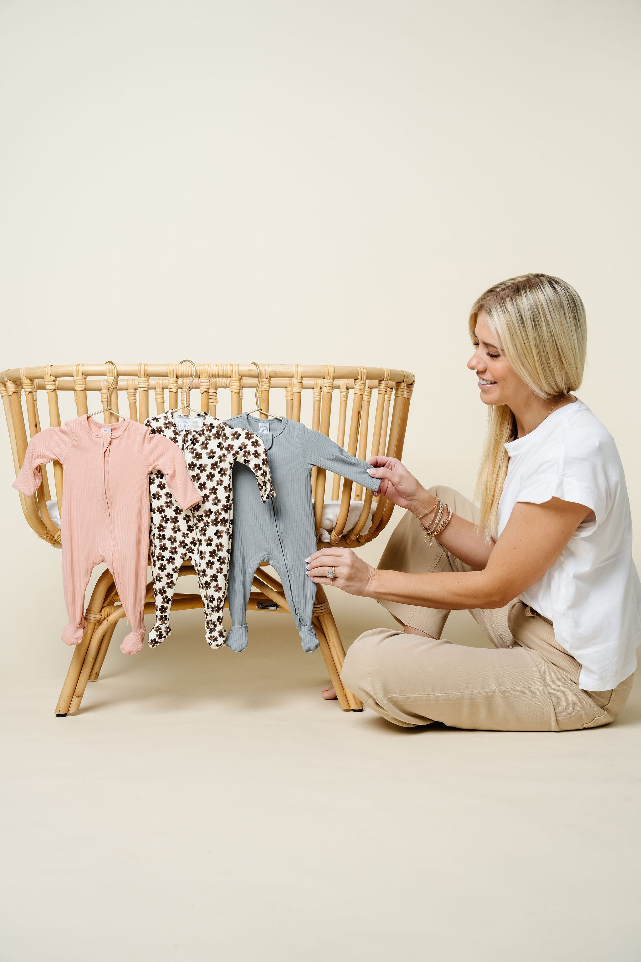 Audrey, Sloane, Ford zipper footies launch hanging on bassinet with Karen