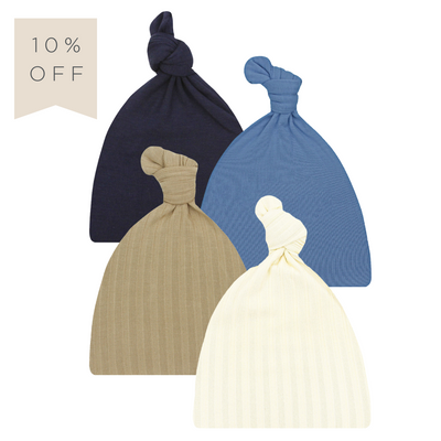 A set of four hats in different colors, including beige, blue, navy, and white, all styled with a top knot.