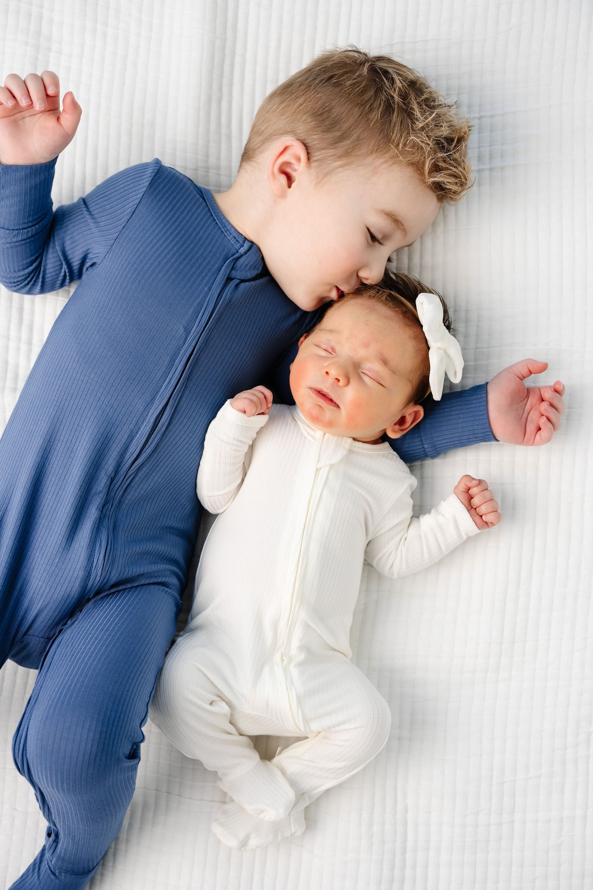 Wren zipper footies newborn baby girl laying with big brother harrison zipper footies wearing 2T size