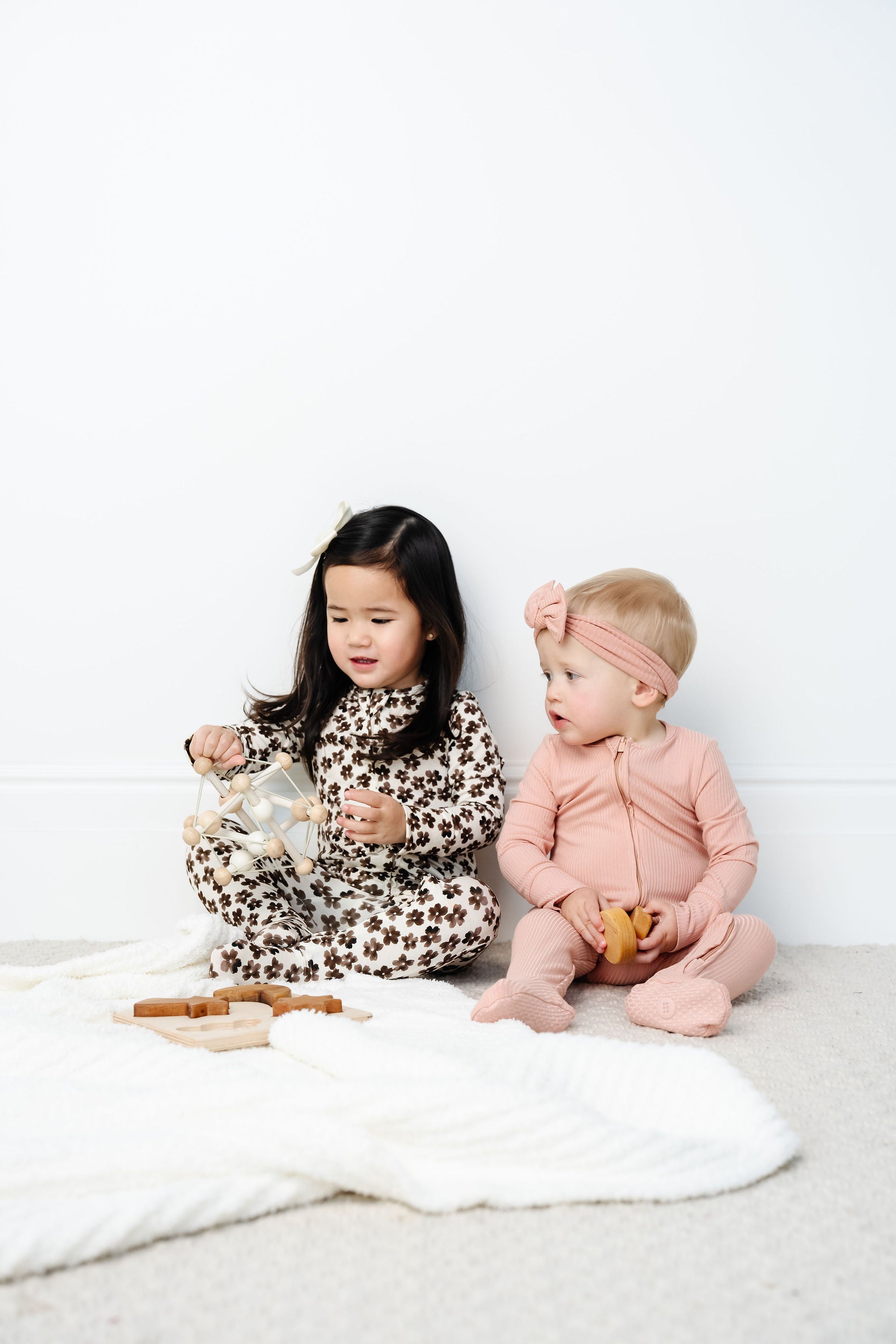 audrey and sloane zipper footies toddler girls wearing 12-24 month and 2T size sitting on blanket playing