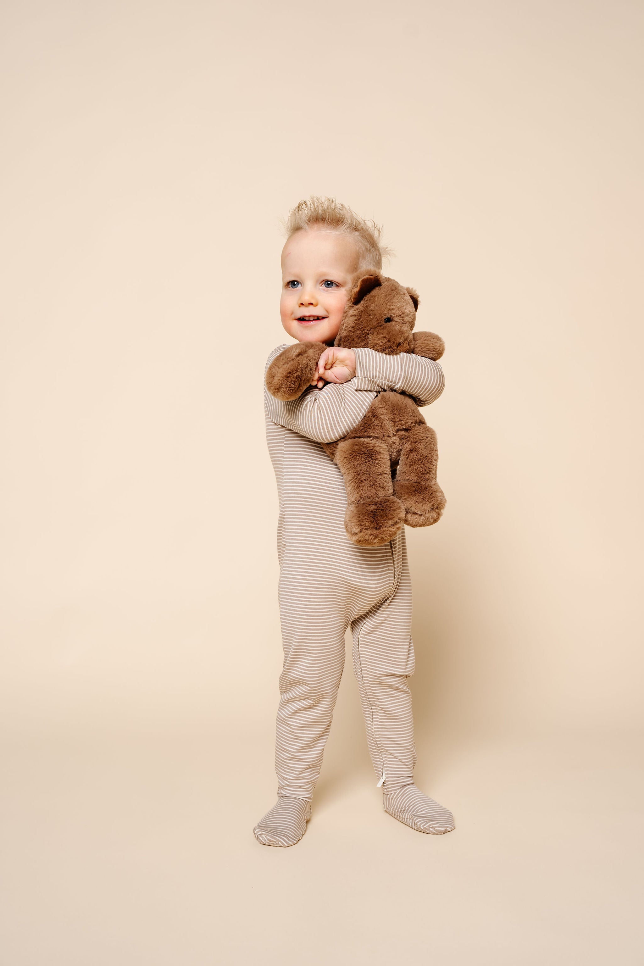 banks zipper footies toddler boy standing with teddy bear