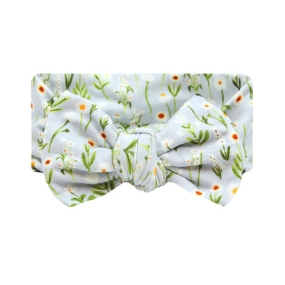 A headband with a white background featuring a floral pattern with green leaves and orange flowers.