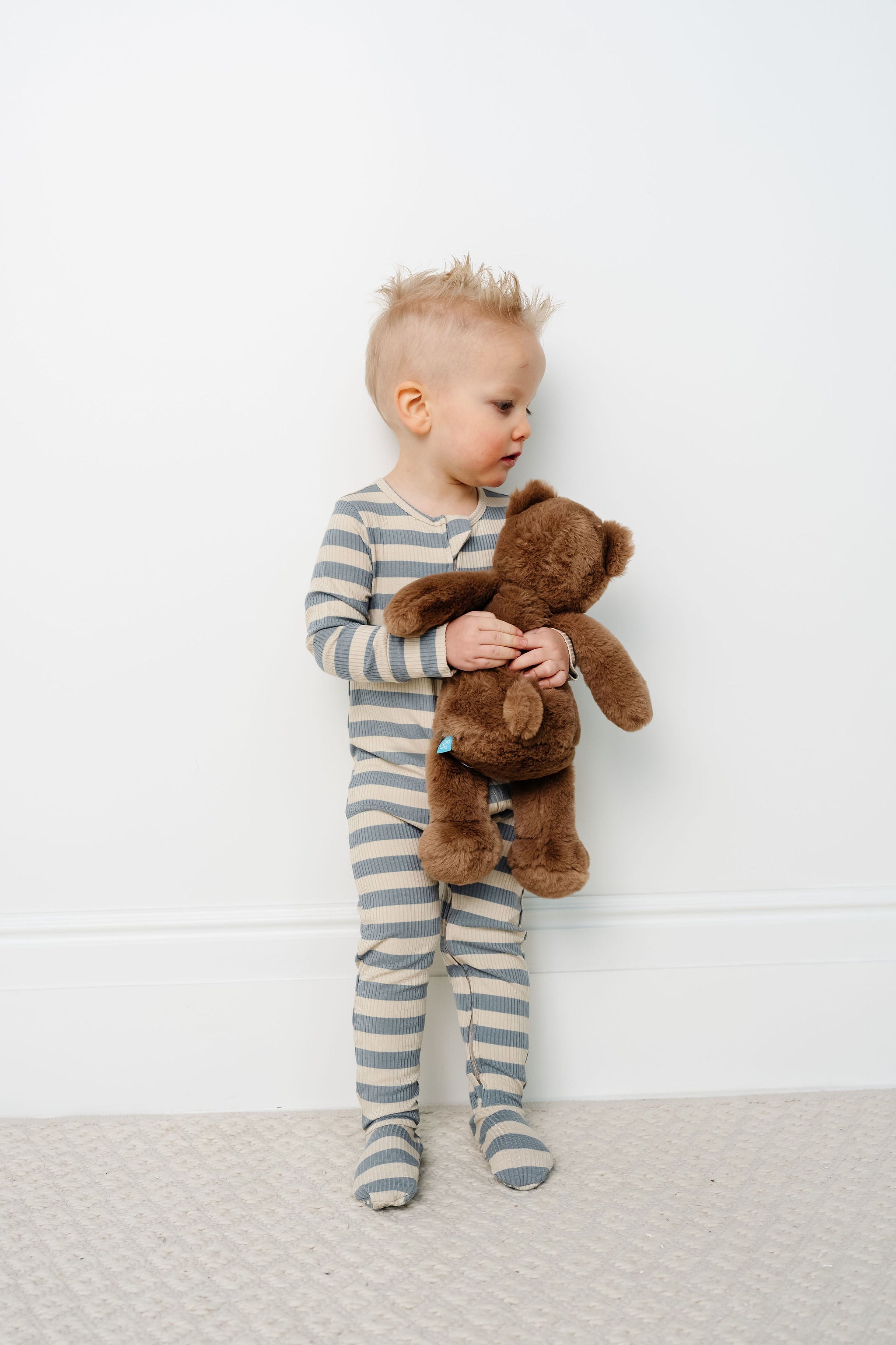 lincoln zipper footies toddler boy standing with teddy bear