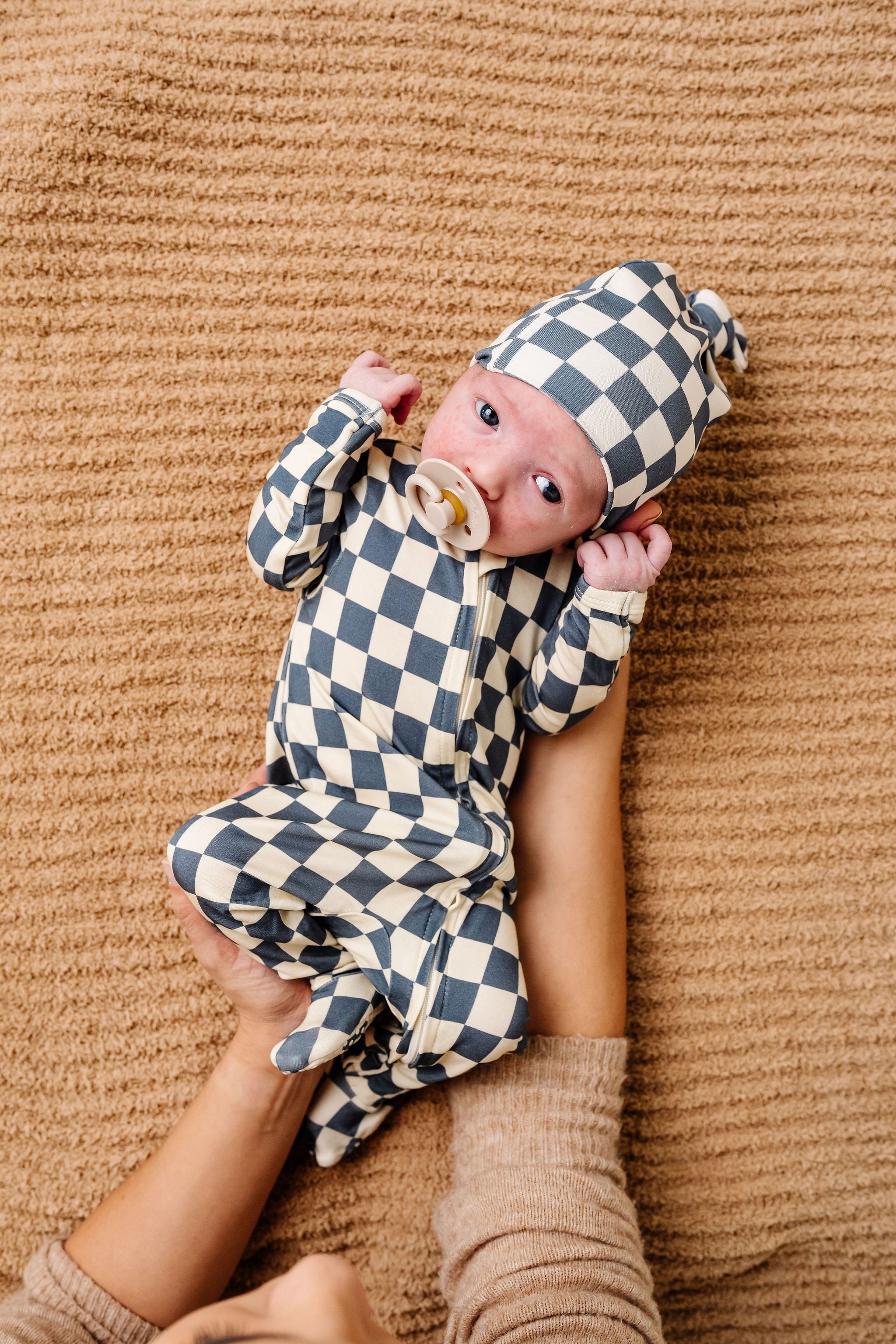 miles zipper footies newborn boy laying on tan chenille blanket