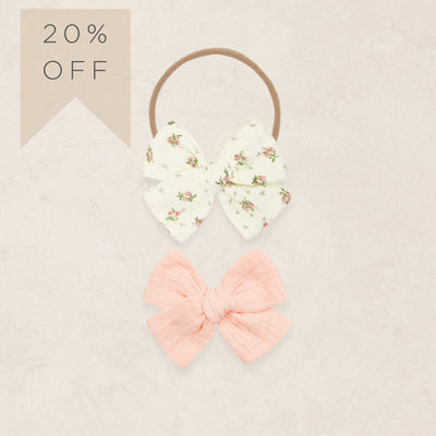 Two hair bows, one floral and one pink, on a beige background with a '20% OFF' label.