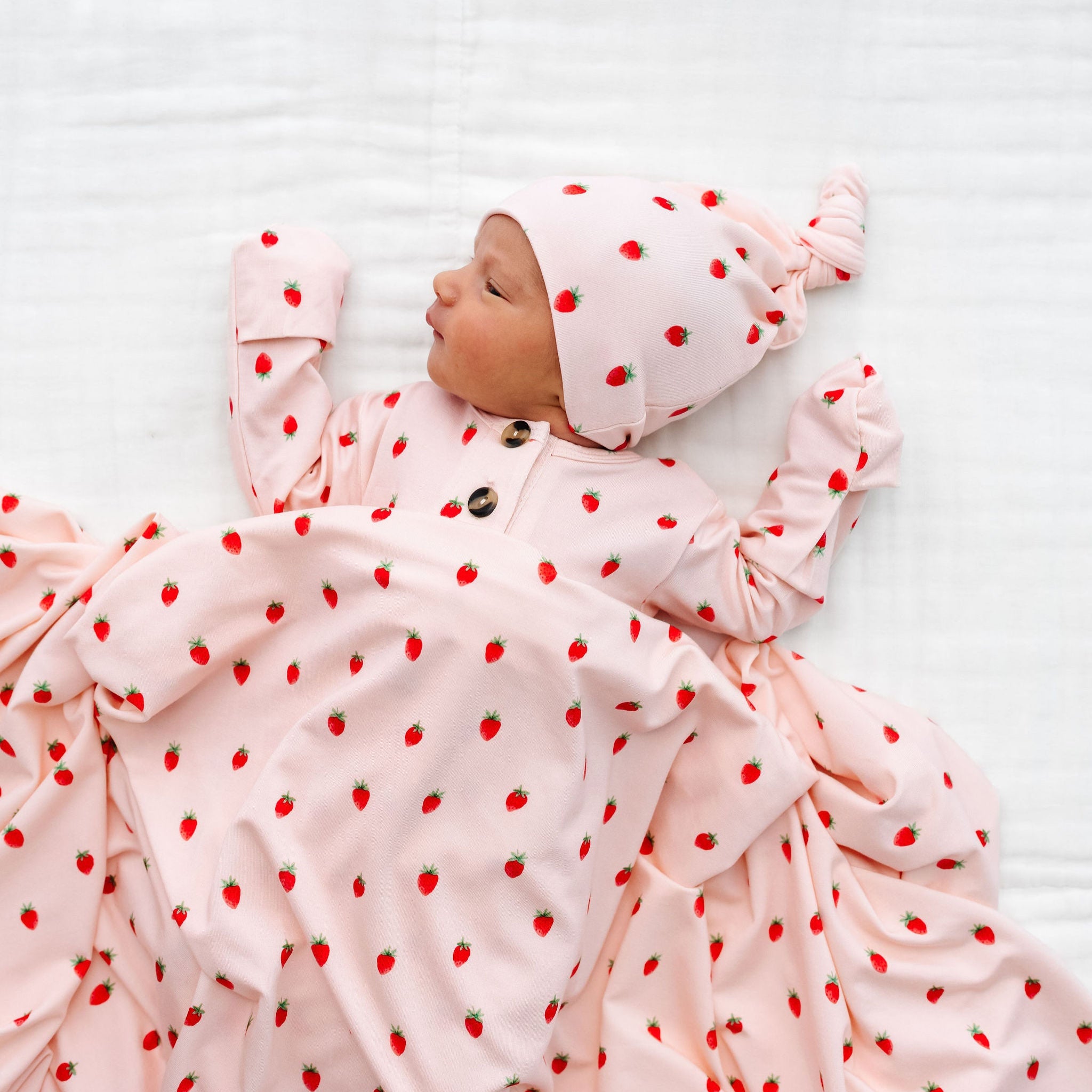strawberry junie print top knot hat newborn girl. with swaddle covering the top and bottom set