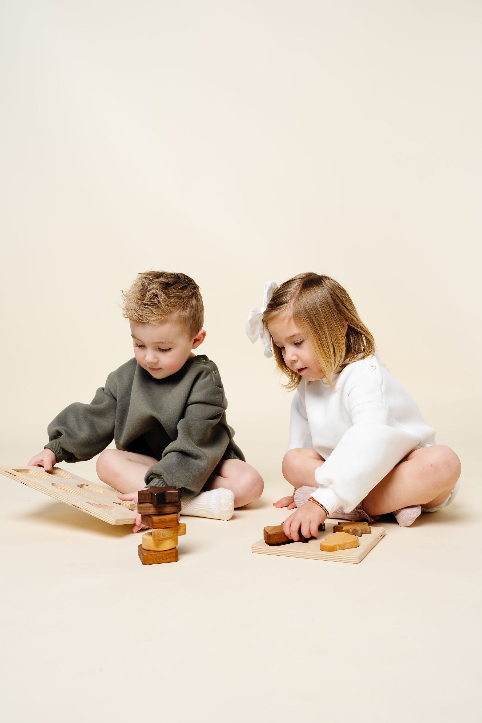 white olive sweatshirt romper toddler boy and girl playing with toys