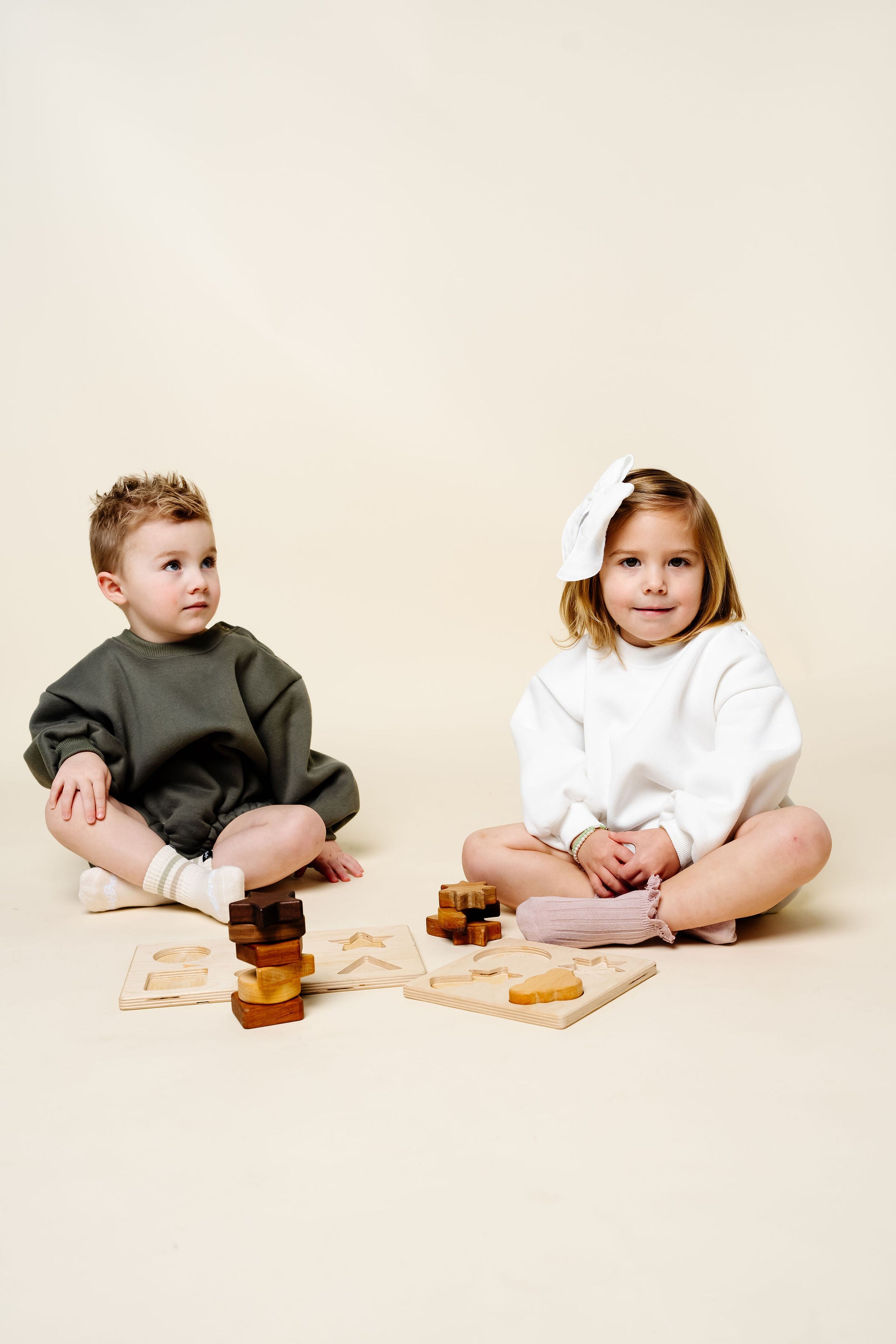 white olive sweatshirt romper toddler boy and girl playing with toys