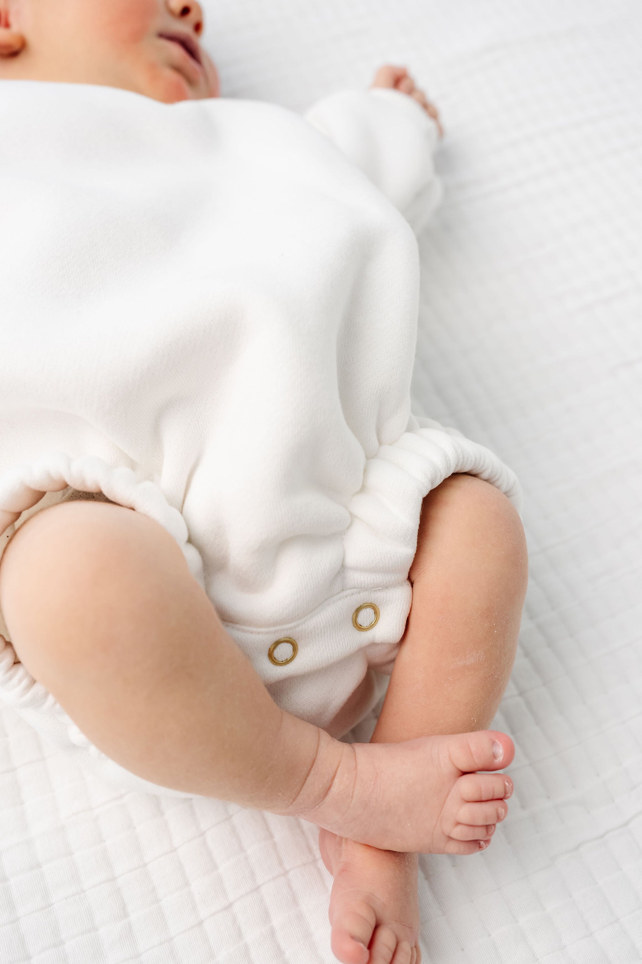 white sweatshirt romper zoom on details on romper snaps