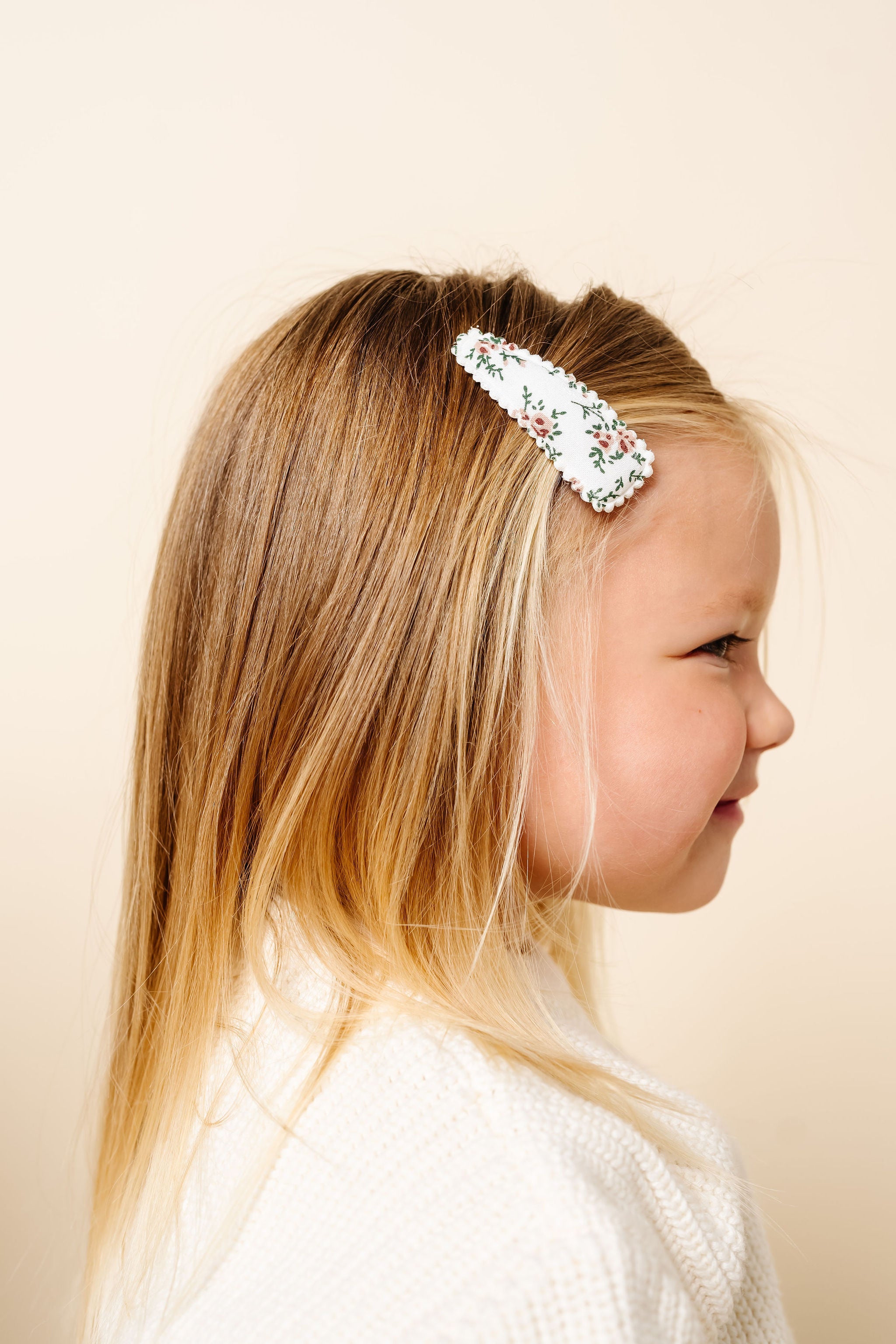 Young girl wearing a decorative headband against a plain background
