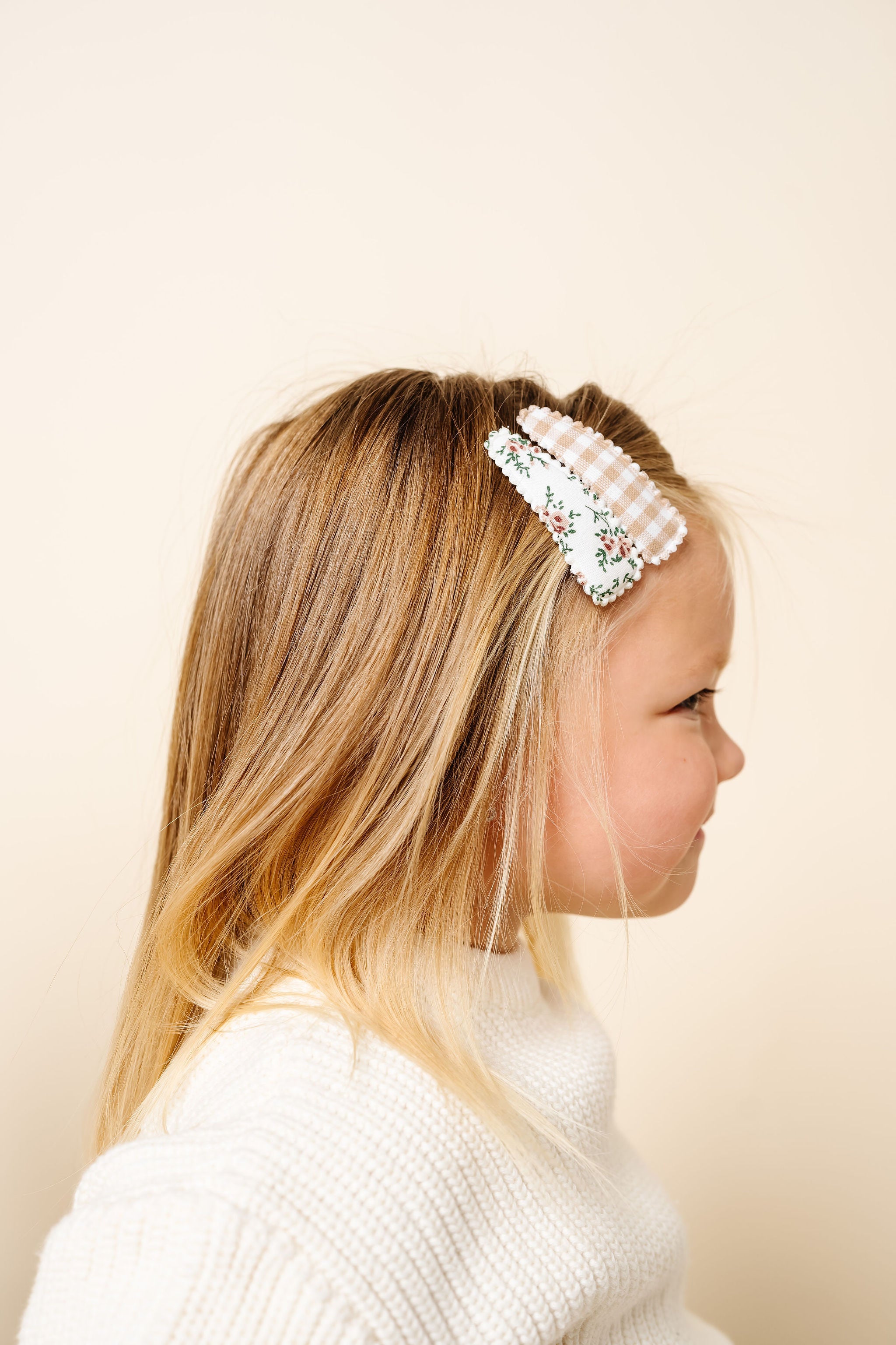 Young girl wearing a decorative headband with a plain background