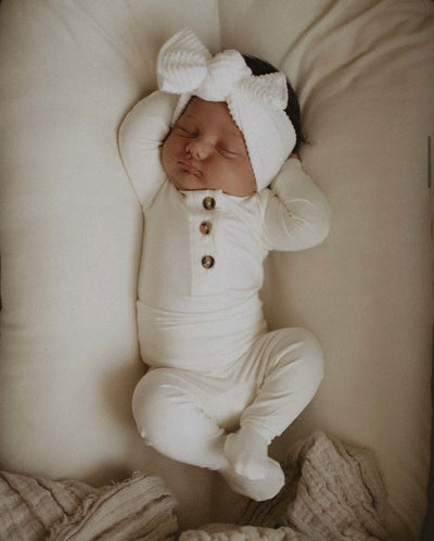 baby girl newborn in finley top and bottoms. laying in a snuggle me. 