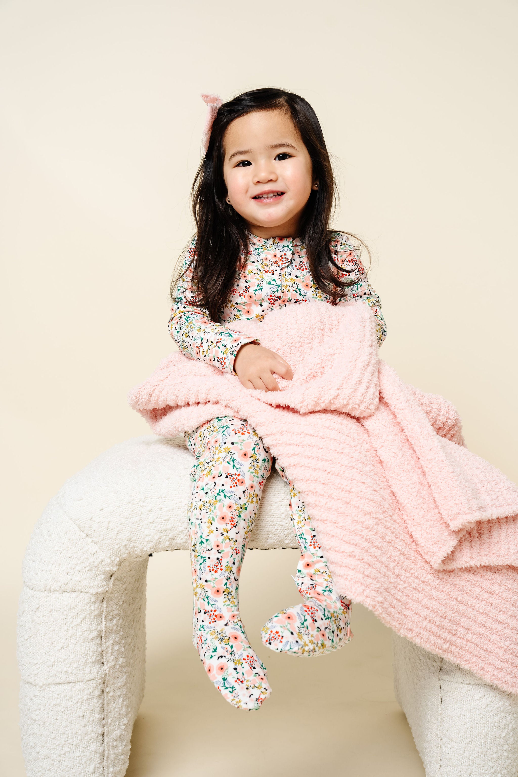 Millie Zipper Footies Toddler Girl in 2T size sitting with blush chenille blanket