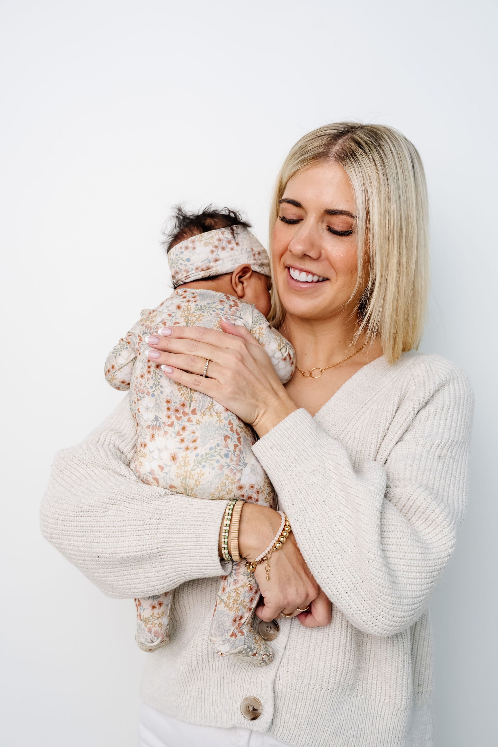 pearl zipper footies being held by karen newborn girl