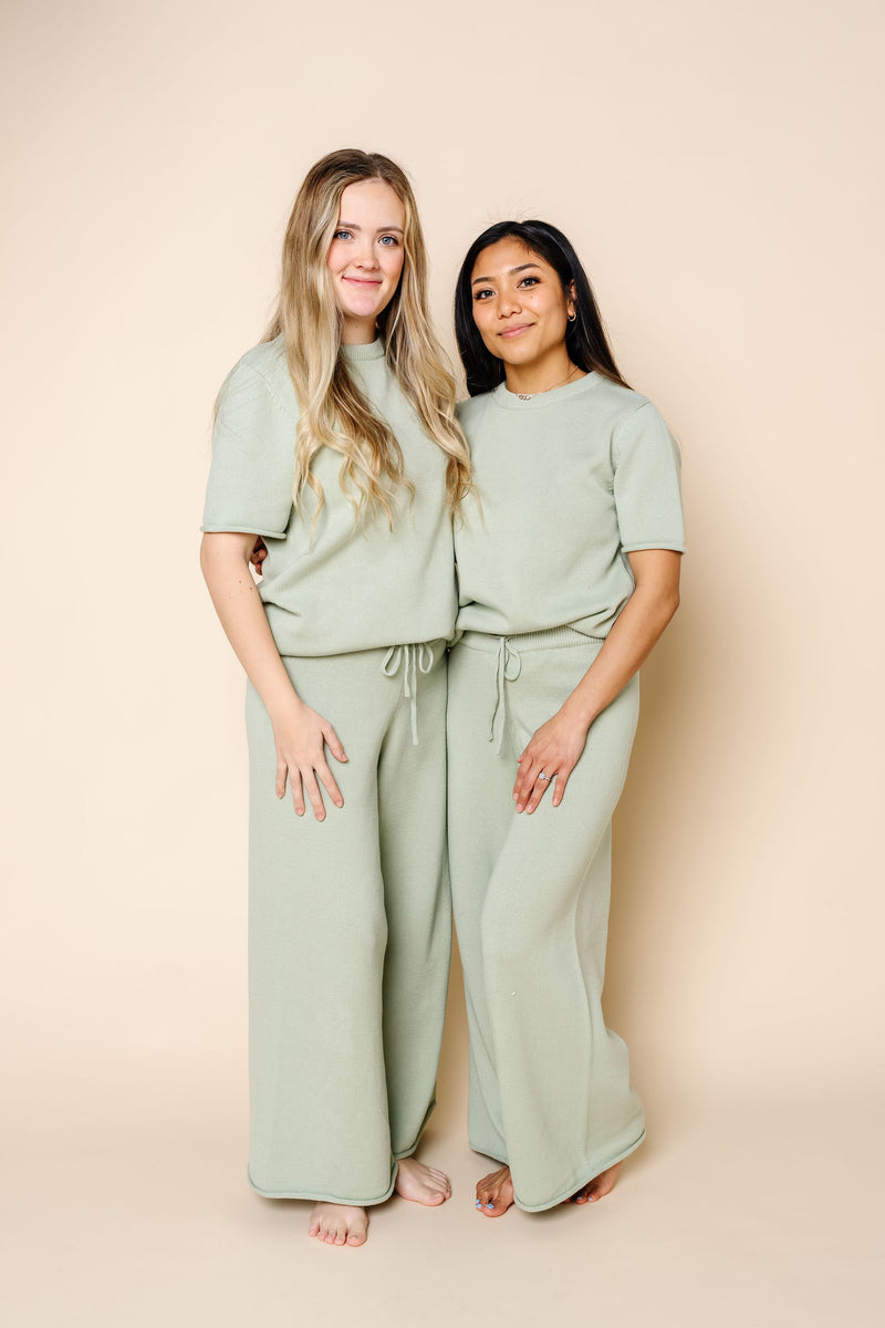 sage knit women's tee and pants. 2 women standing. one in size small and one in size medium